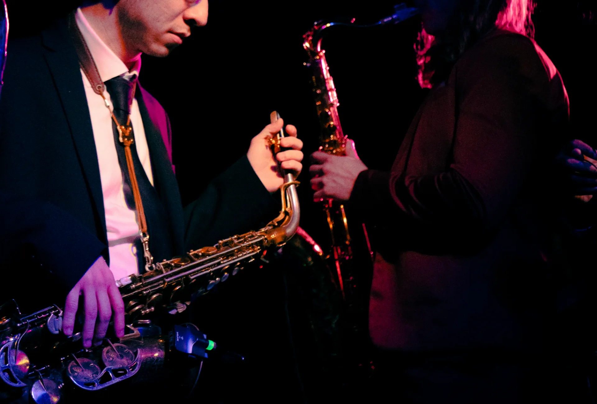 The horn players performing side by side in black-tie