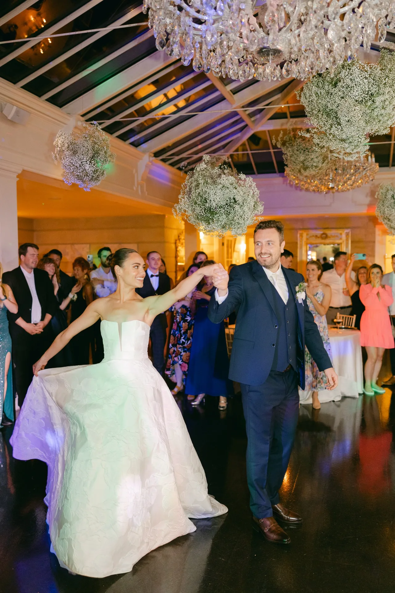 Saxophonist performing on the dance floor as a couple celebrates at their wedding reception